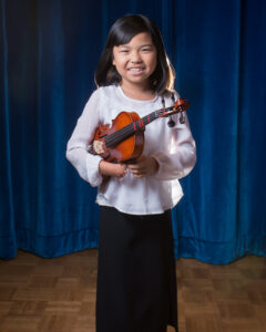 Young girl with a limb difference holding a violin